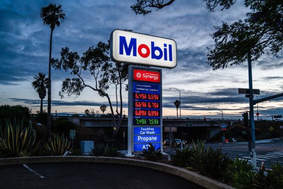 A sign displays fuel prices at a Mobil gas station