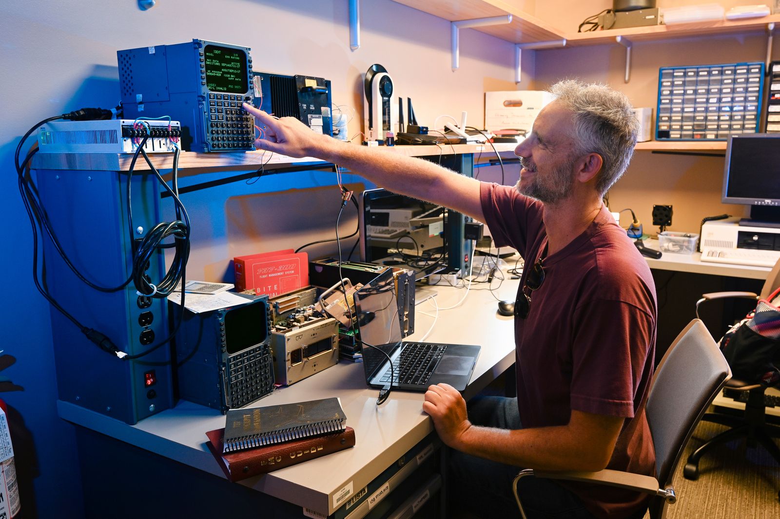 UCSD professor Aaron Schulman pushing a button on the Flight Management Computer that's part of the researchers' Triton...