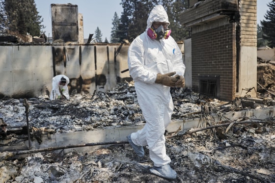 Two brothers work to recover items their mother's home on Aug. 5, 2026 in Spokane, Wash.