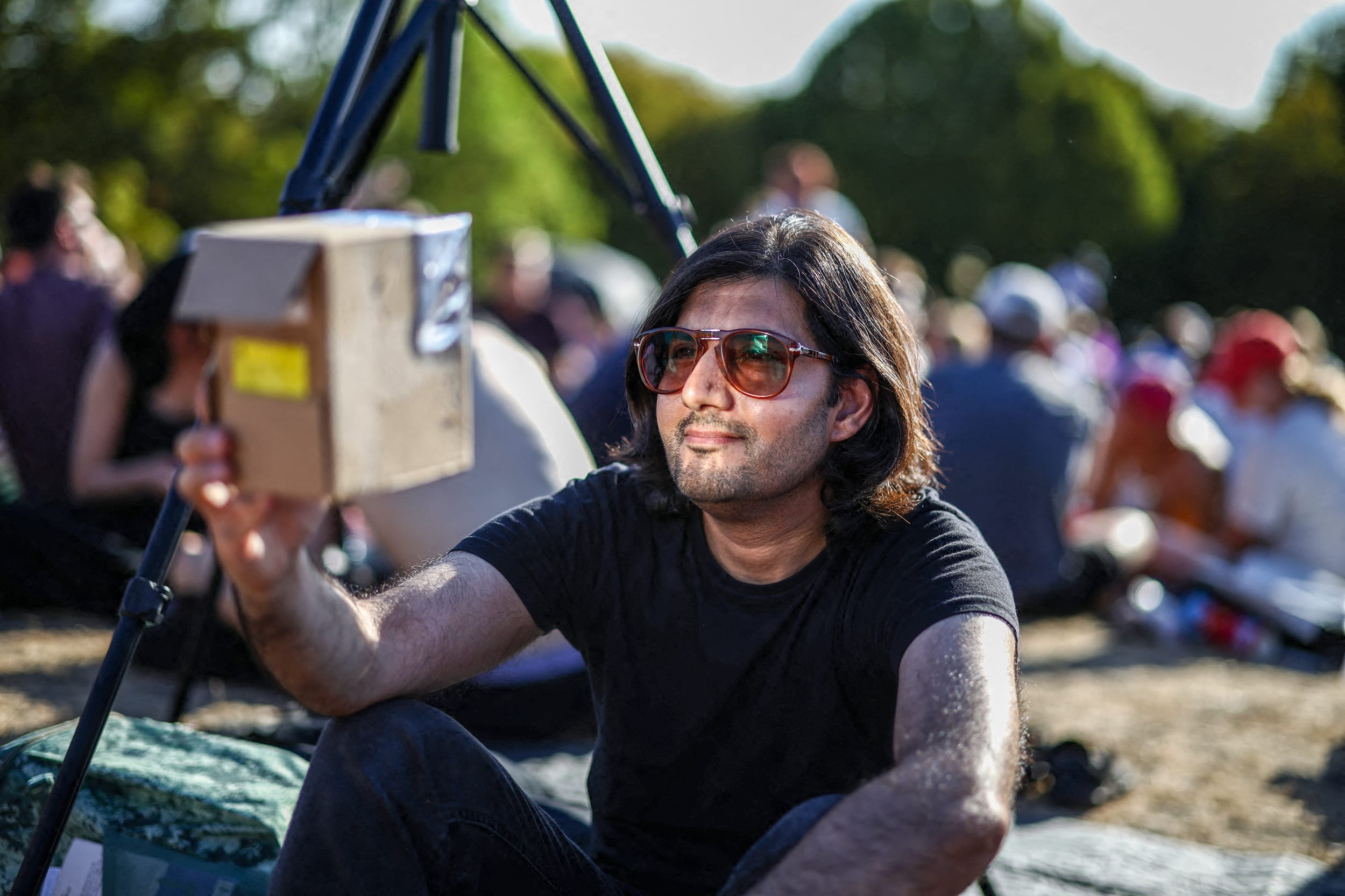 A man waits with others on Primrose Hill in the hope of watching a near total solar eclipse.