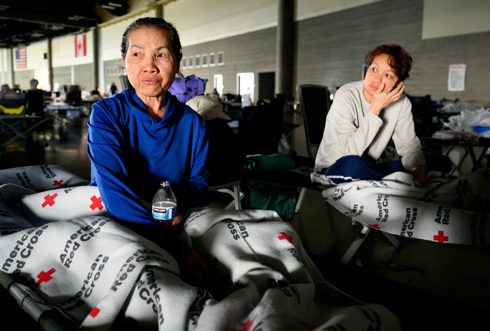 A woman and her daughter wait for news on the status of their home at a Red Cross evacuation center in Spokane...