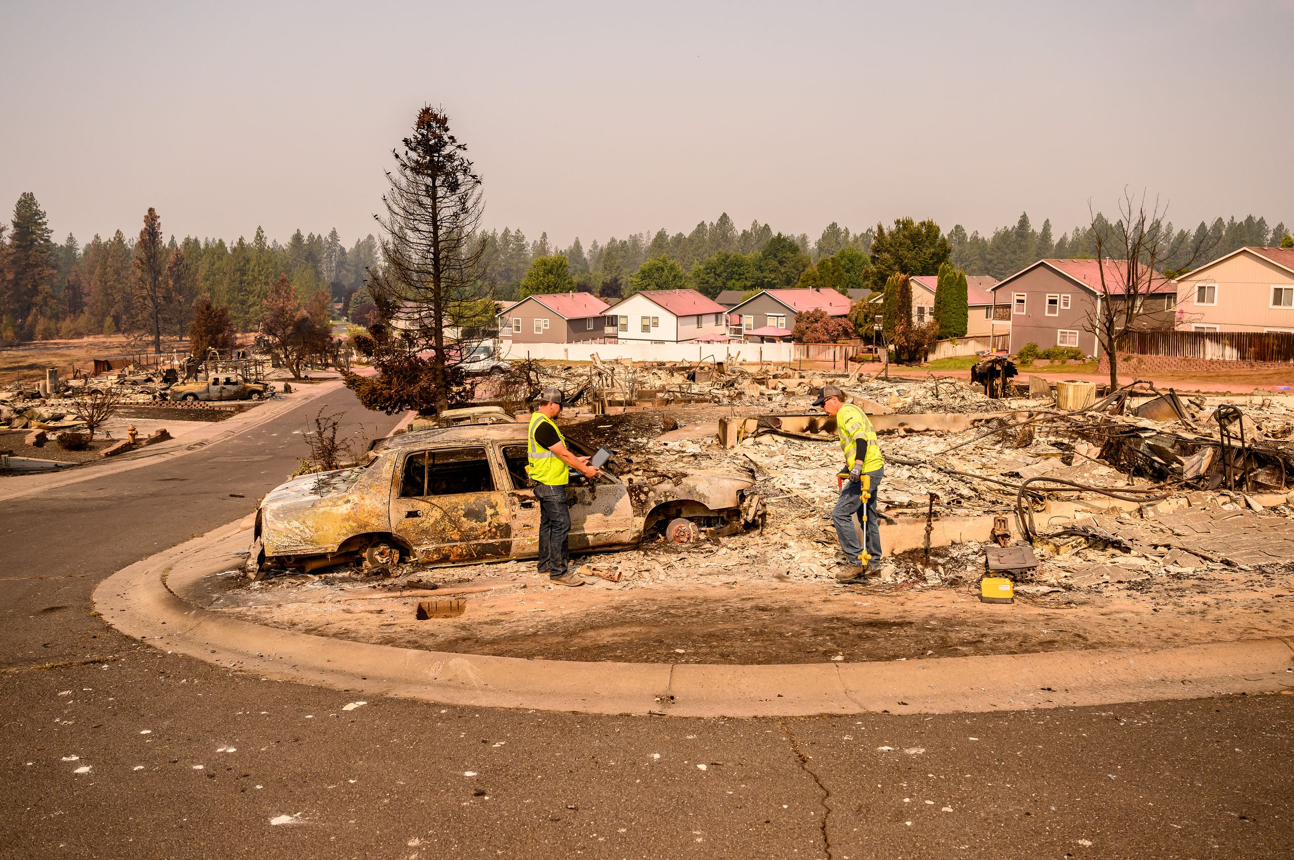 Utility workers help clear obstacles at a home burned during the Old Trails Fire in Spokane Washington on August 4 2026.