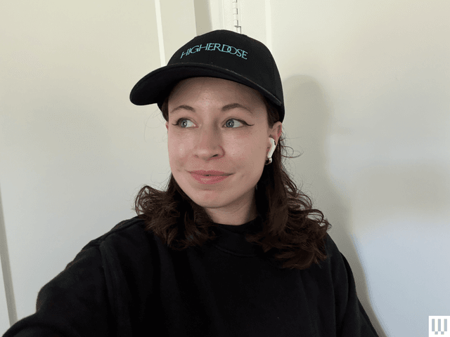 Image may contain: Baseball Cap, Cap, Clothing, Hat, Adult, Person, Face, Head, Earbuds, and Electronics