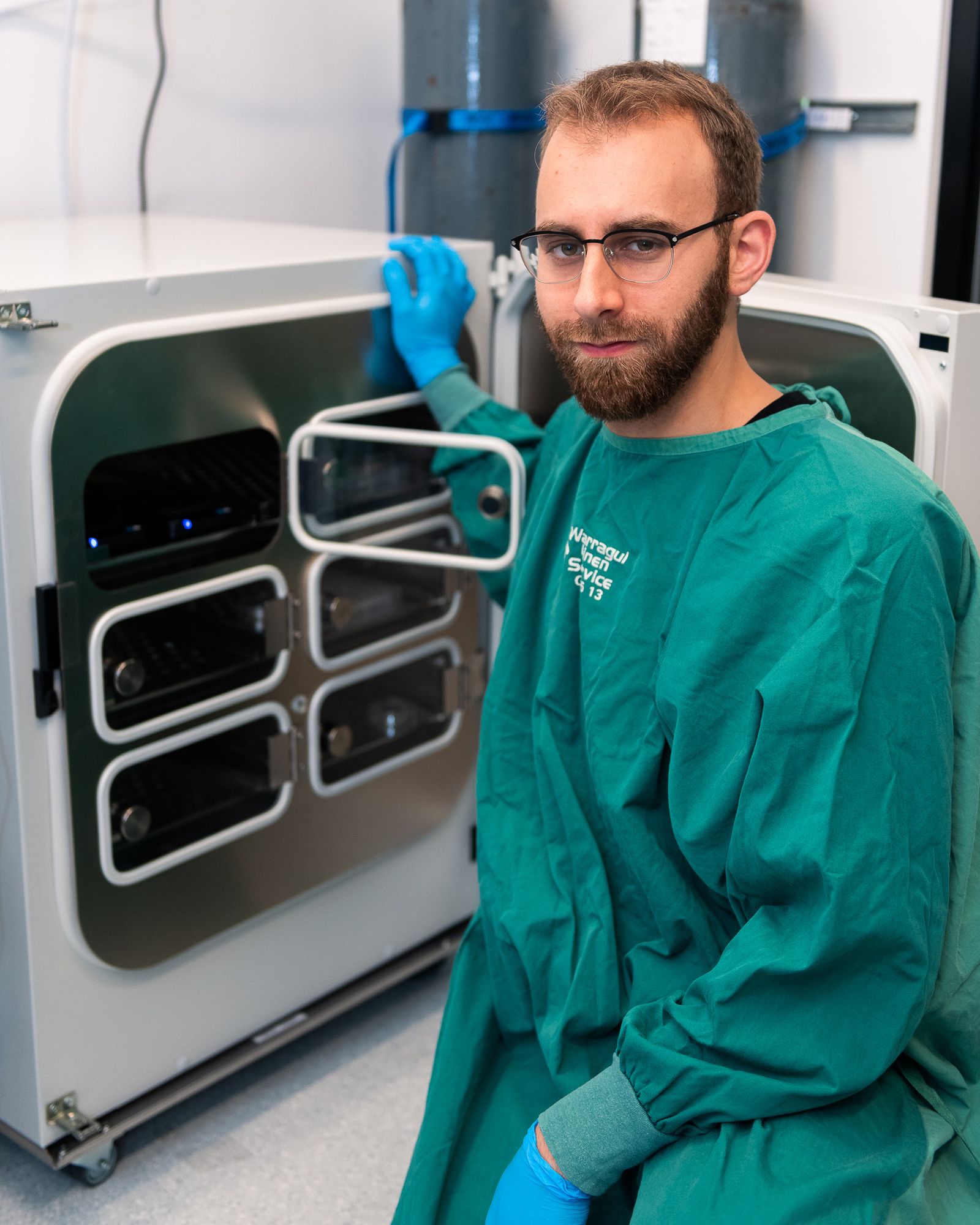 Brett Kagan wearing a lab coat in front of the device