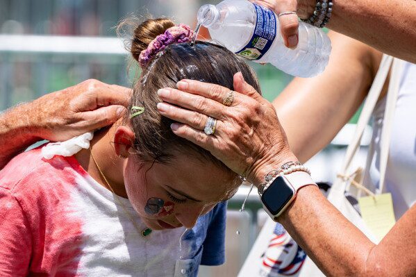 Ruth, 11, from Burke, Va., gets cold water poured on her head to cool off at the Great American State Fair on the National Mall, July 2, 2026, in Washington. (AP Photo/Alex Brandon, File)