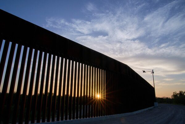 The sun sets over a section of the border wall, June 18, 2025, in Mission, Texas. (AP Photo/Jacquelyn Martin, File)