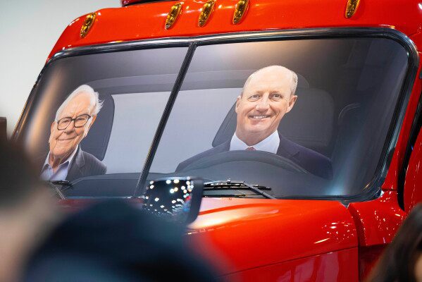 Portraits of Berkshire Hathaway's Warren Buffett, left, and CEO Greg Abel sit in a semi truck at the Pilot display in the Berkshire Hathaway annual meeting on May 2, 2026, in Omaha, Neb. (AP Photo/Rebecca S. Gratz, file)