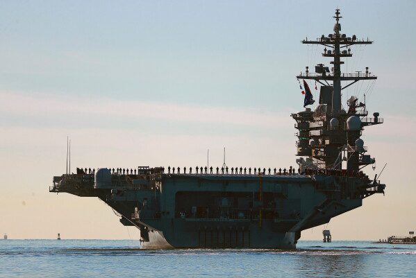 Sailors and Marines line the deck of aircraft carrier USS Abraham Lincoln (CVN-72) as it deploys from San Diego, Jan. 3, 2021. (K.C. Alfred/The San Diego Union-Tribune via AP, File)