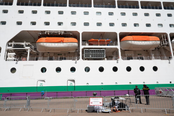 A barrier is set in front of the British cruise ship Ambition, as French authorities have ordered 1,700 passengers and crew to stay on board due to a gastrointestinal illness outbreak, in Bordeaux, southwestern France, Wednesday, May 13, 2026. (AP Photo/Caroline Blumberg)