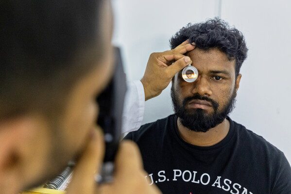 An eye care professional from VisionSpring examines a worker at a garment factory in Gazipur, on the outskirts of Dhaka, Bangladesh, June 30, 2026. (AP Photo/Rajib Dhar)