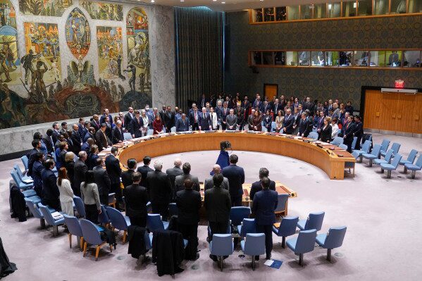 Participants in a Security Council meeting rise for a moment of silence at United Nations headquarters, Feb. 24, 2023. (AP Photo/Seth Wenig, File)