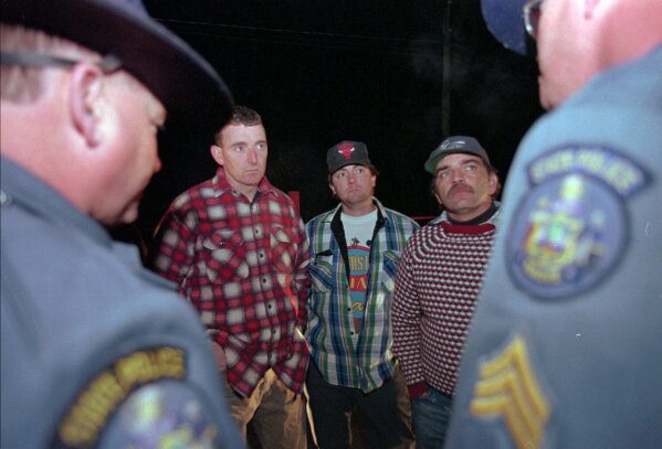 Maine loggers Stacey Kelly, second from left, Troy Jackson, and Hilton Hafford are threatened with arrest by Maine State Police if they continue to block access to Canadian woodsmen at the border at St. Pamphile, Quebec, Monday, Oct. 26, 1998. (AP Photo/Robert F. Bukaty,File)