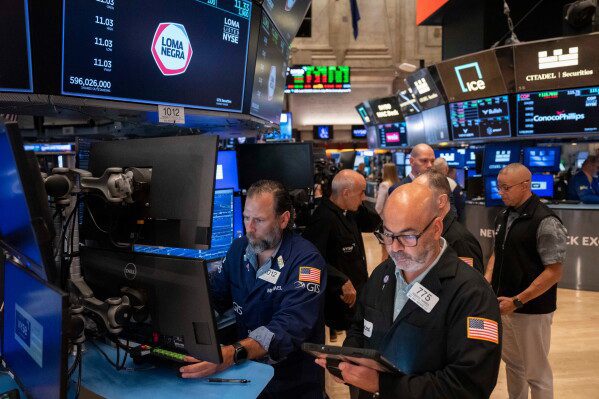 Trader Fred Demarco, right, and Specialist Michael Pistillo, left, work on the floor of the New York Stock Exchange, Friday, Aug. 7, 2026, in New York. (AP Photo/Yuki Iwamura)