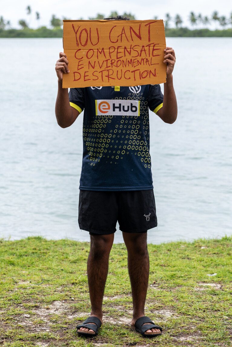 A demonstrator holds a sign while participating in an action as part of Project ThimaaVeshi, a youth-led protest against ongoing reclamation projects damaging mangroves, in Addu City, Maldives, June 3, 2026. (AP Photo/Sophia Nasif)