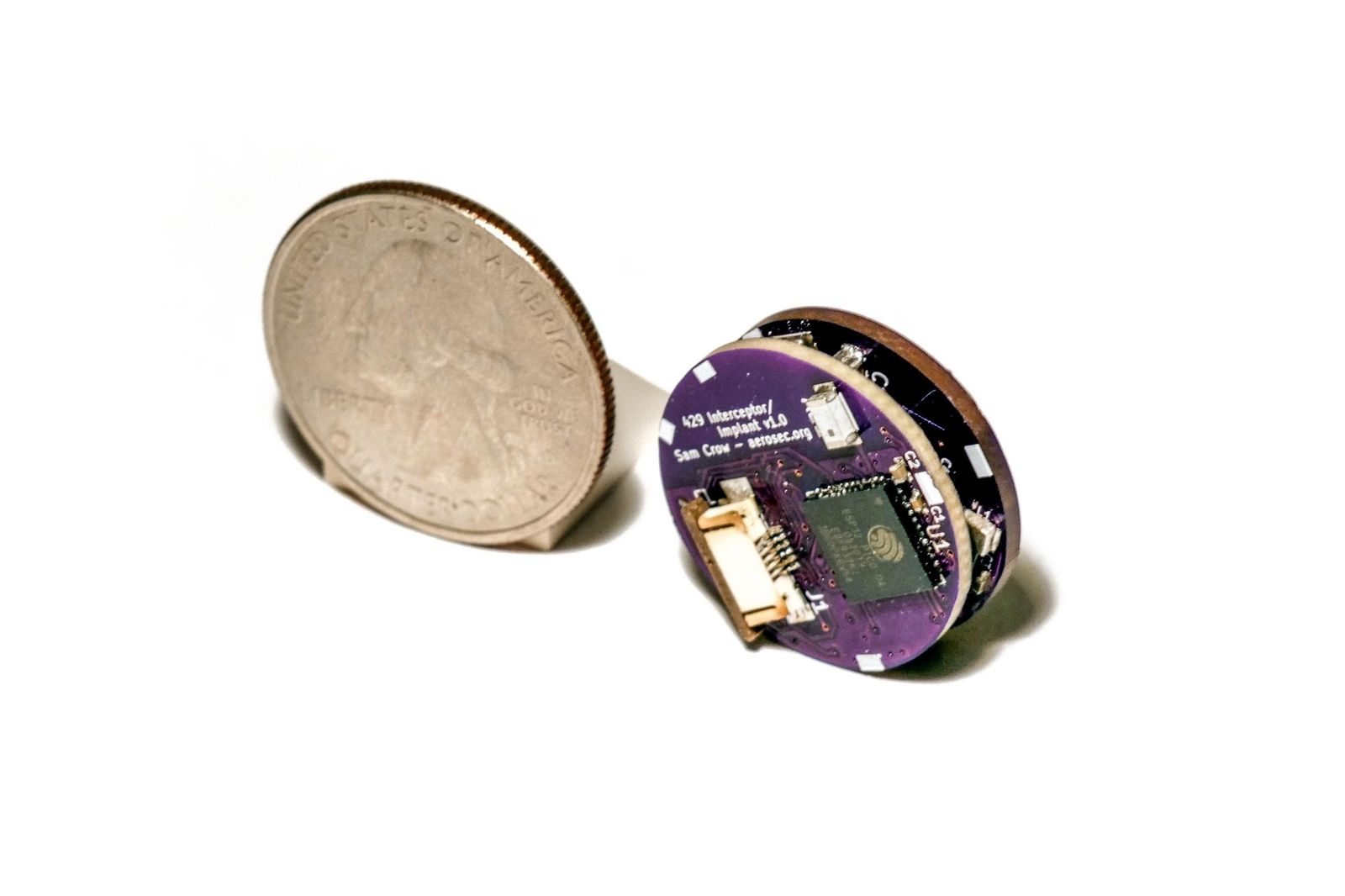 The researchers' hacking device next to a quarter for scale.